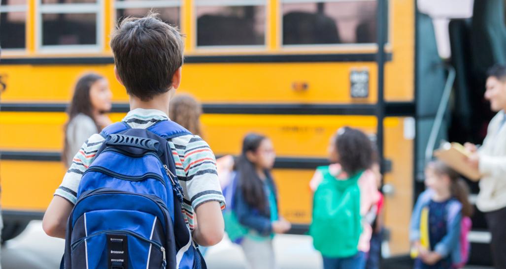 Boy waits to get on school bus