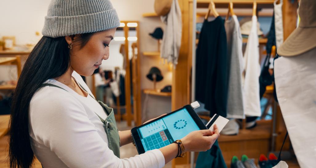 Store clerk runs credit card through tablet 