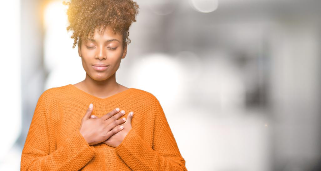 Woman with hands over heart and eyes closed