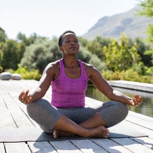 Woman in a yoga pose near the water