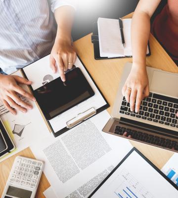 Hands pointing at tech devices workstation